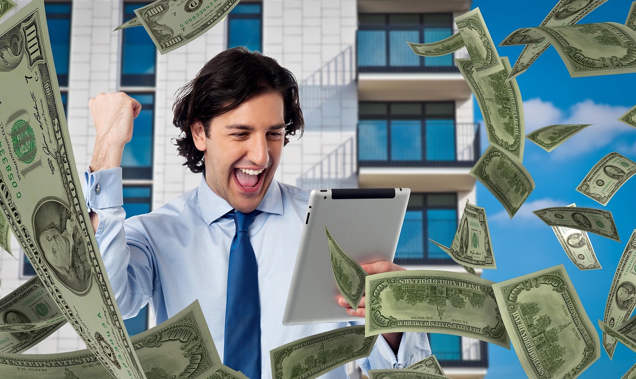 Man, money, tablet — Progressive Jackpots: Are They Worth the Risk?