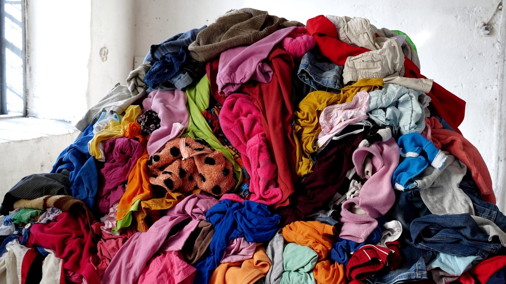 A large pile of colorful clothes in disarray